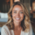 Femme souriante à l'intérieur, cheveux blonds.
